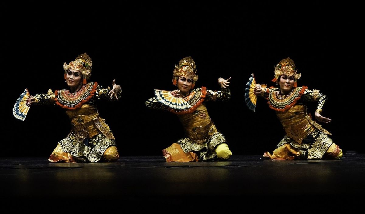 three ladis in balinese costumes dancing