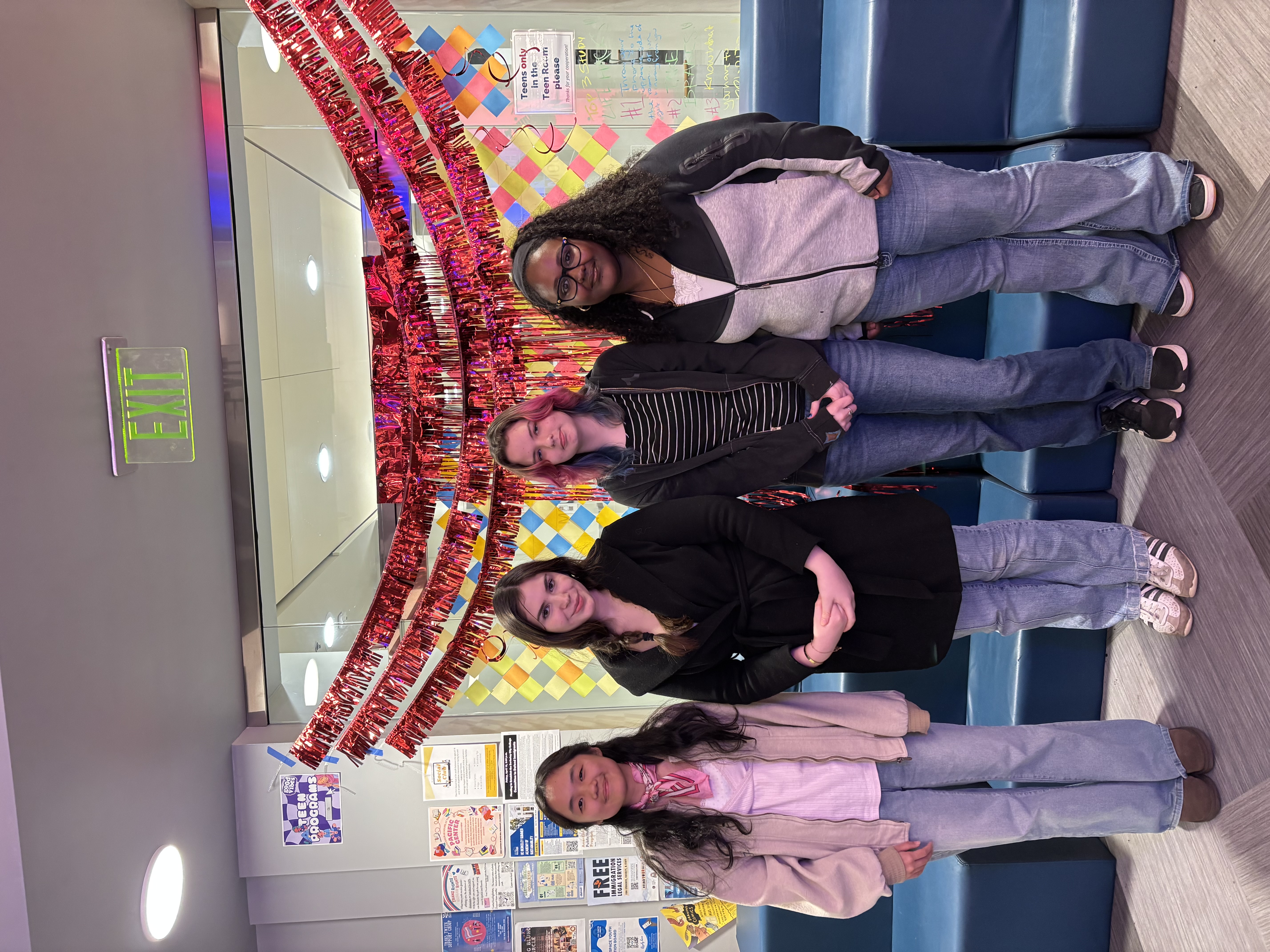 Four young women standing for a portrait in a festive room