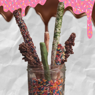7 homemade oversized candy sticks dipped in chocololate and candy  arranged in a jar full of sprinkle